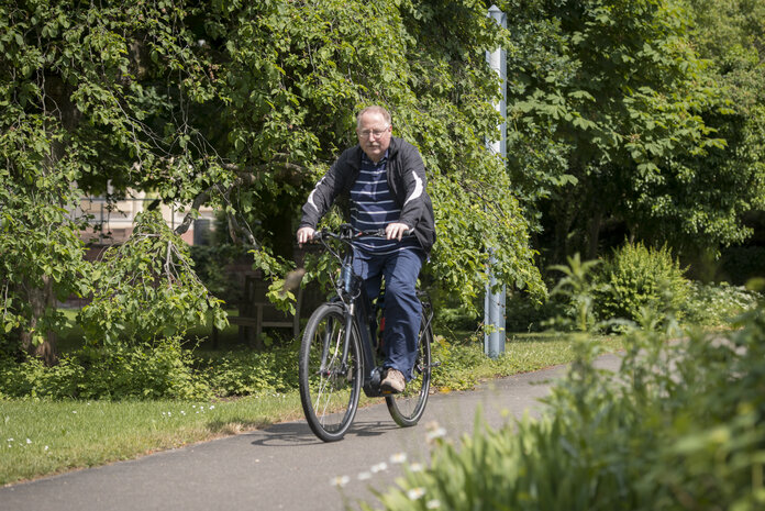 Ein Mann fährt mit dem Fahrrad auf einem Fahrradweg durch die Natur