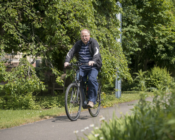 Ein Mann fährt mit dem Fahrrad auf einem Fahrradweg durch die Natur