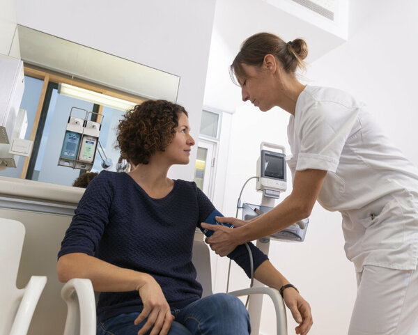 Krankenschwester misst bei Patientin Blutdruck