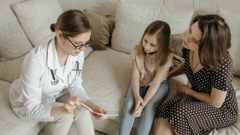 Eine Ärztin erklärt Mutter und Tochter einen Befund.