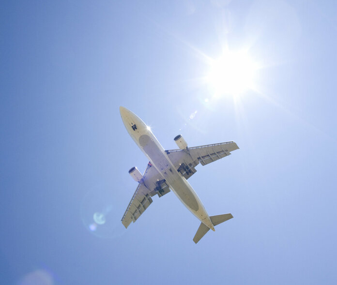 Ein Flugzeug am Himmel bei Sonnenschein.