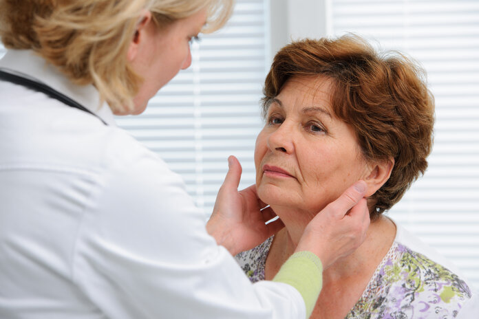 Eine Ärztin tastet die Lymphknoten einer Patientin ab.