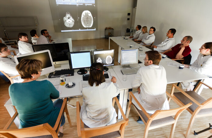 Ärzte aus verschiedenen Fachrichtungen besprechen Krankheitsbild eines Patienten.