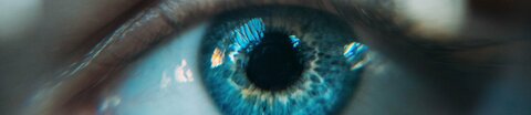 Auge mit blauer Iris in Nahaufnahme