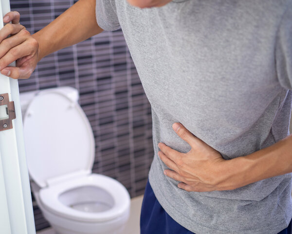 Mann bei Toilette hat Bauchschmerzen