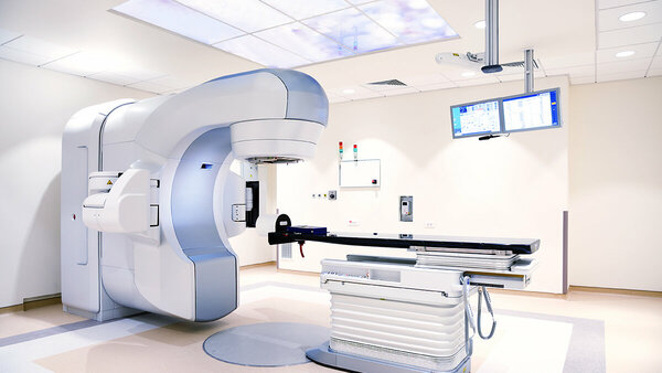 Untersuchungsraum mit elektrischer Untersuchungsliege und Linearbeschleuniger zur Strahlentherapie.